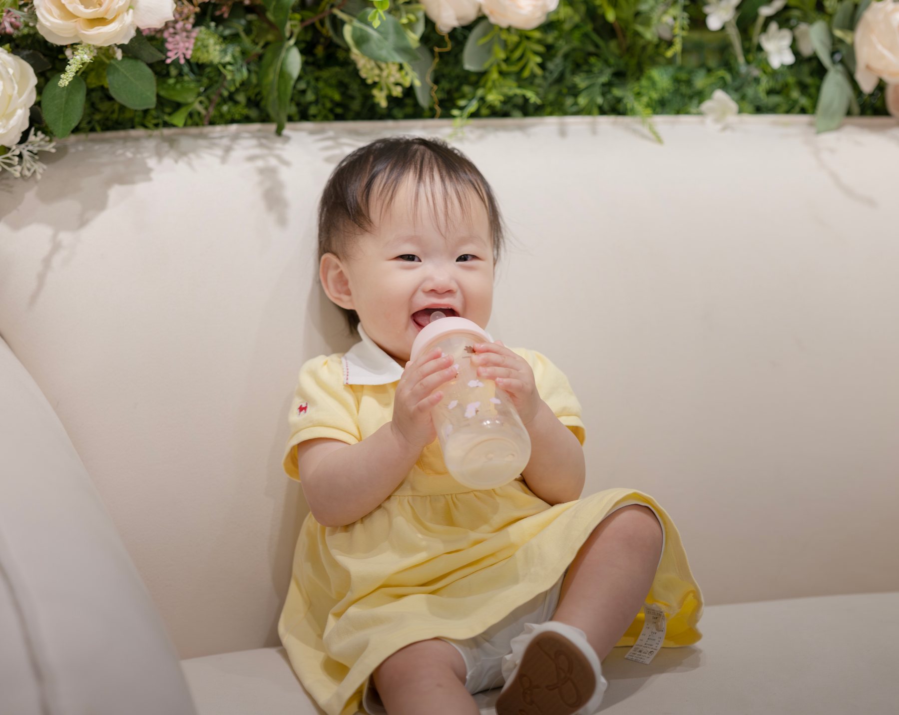 행사 중 편안하게 우유를 먹으며 웃는 아이